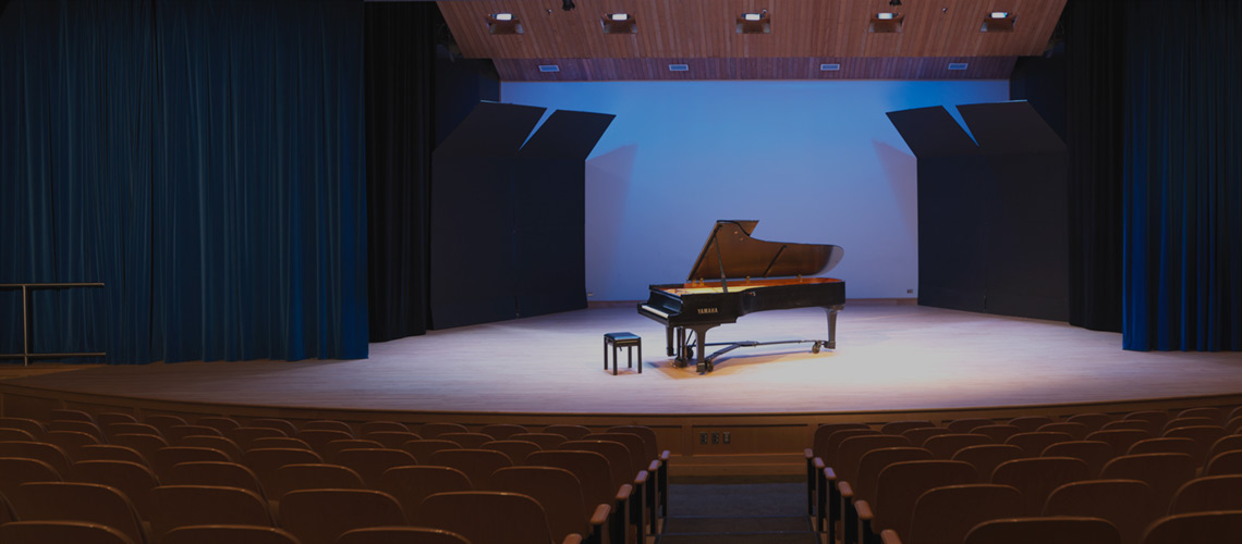 Photo of a grand piano on the stage of the Leacock Theatre